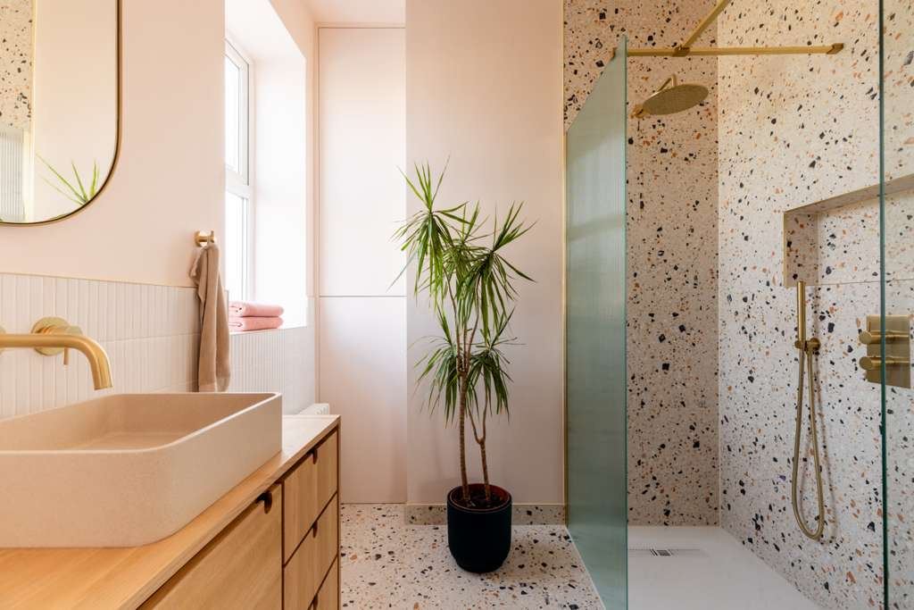 Blush pink bathroom with terrazzo floor and brass fittings