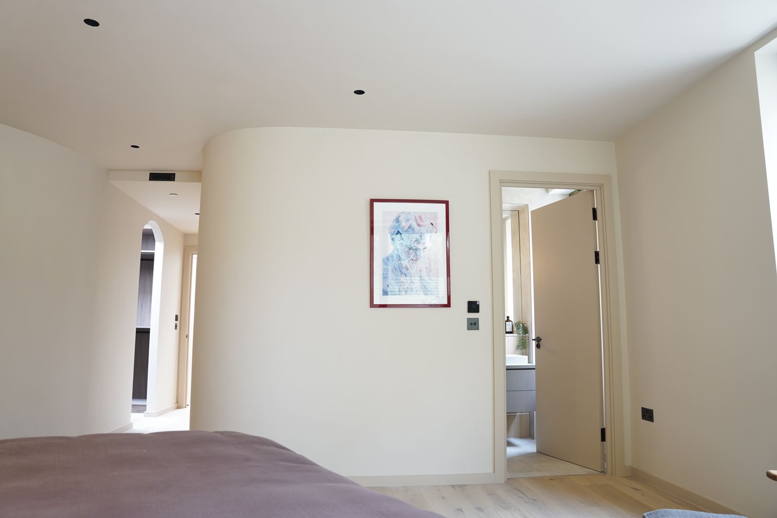 Smooth plastered curved wall in a bright bedroom