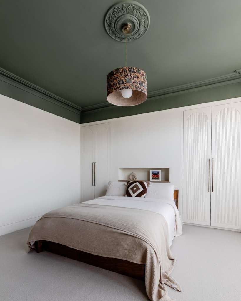 Bedroom with deep green ceiling and crisp white walls