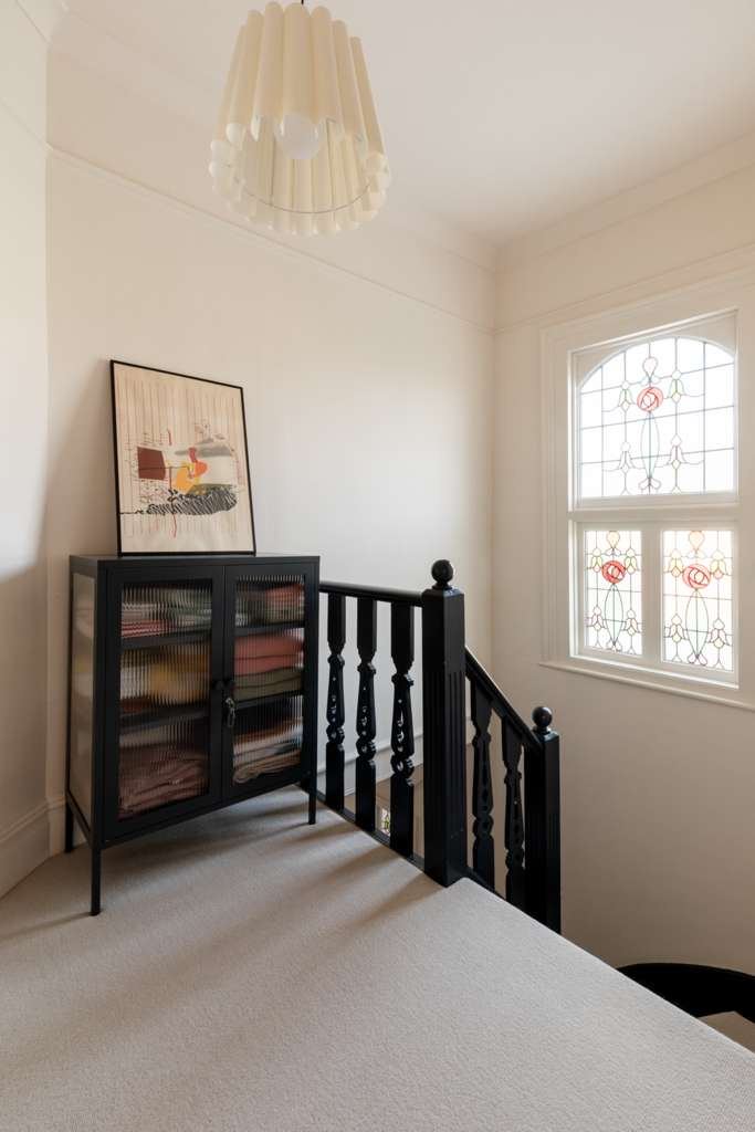 Victorian landing with stained glass window and fresh white walls